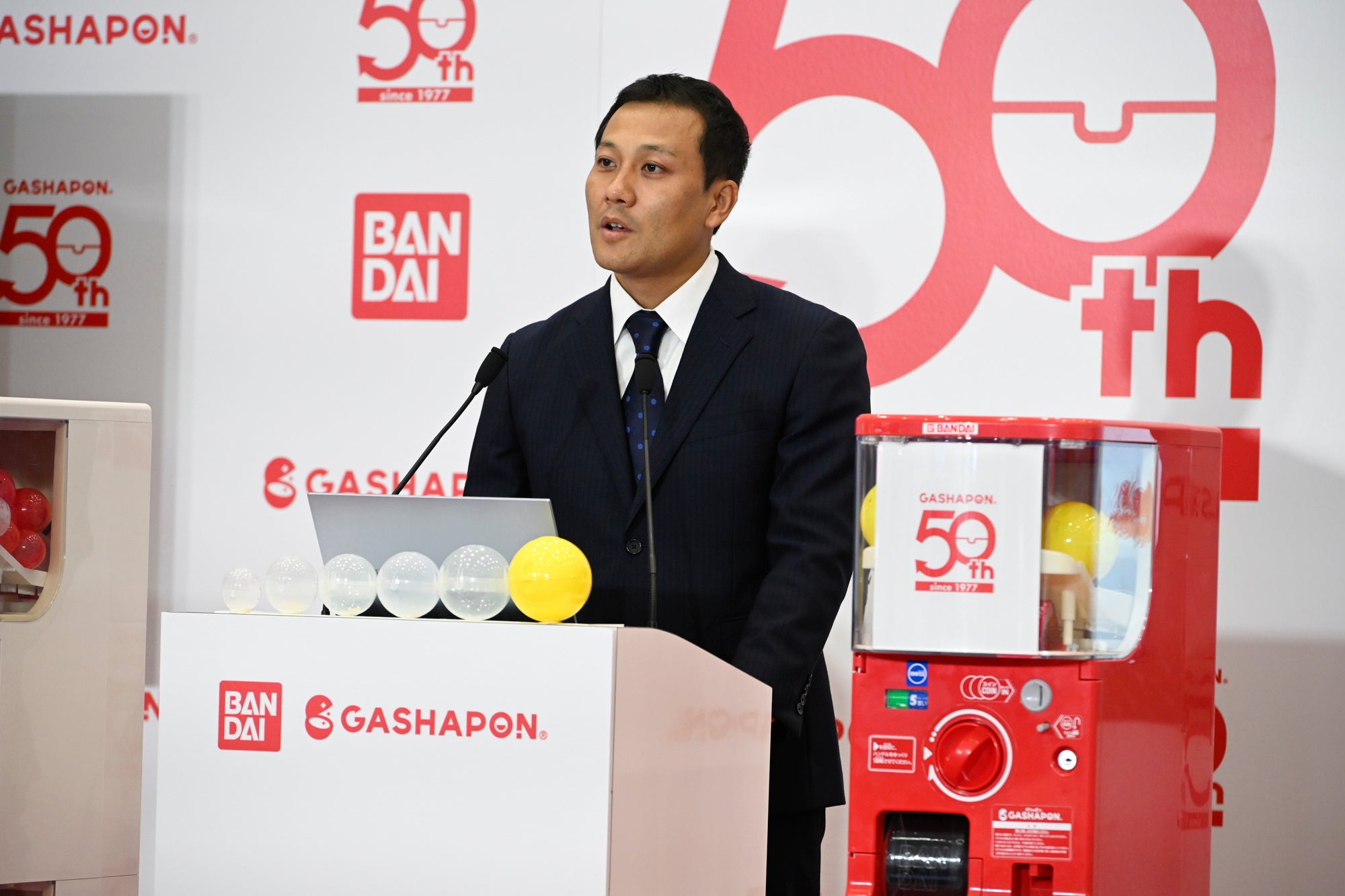 新型自販機を交えたバンダイの発表会写真